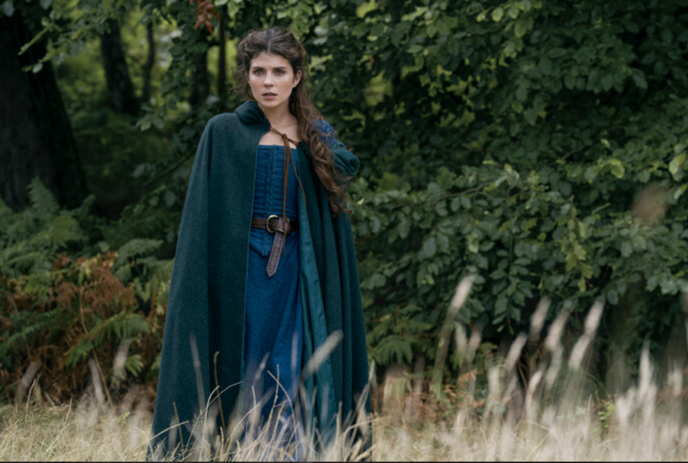 Emily Bader as Jane Grey on 'My Lady Jane' episodic photo of Jane in green cape and blue dress in woods
